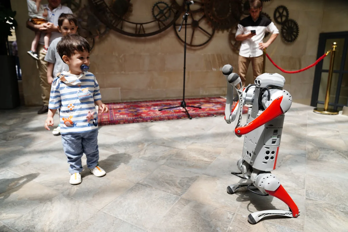 Návštevníci výstavy sledujú humanoidného robota zblízka (Pexels)