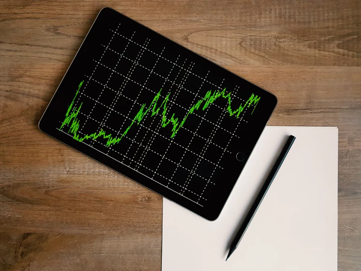 Tablet so zeleným finančným grafom a ceruzka na stole (Pexels)